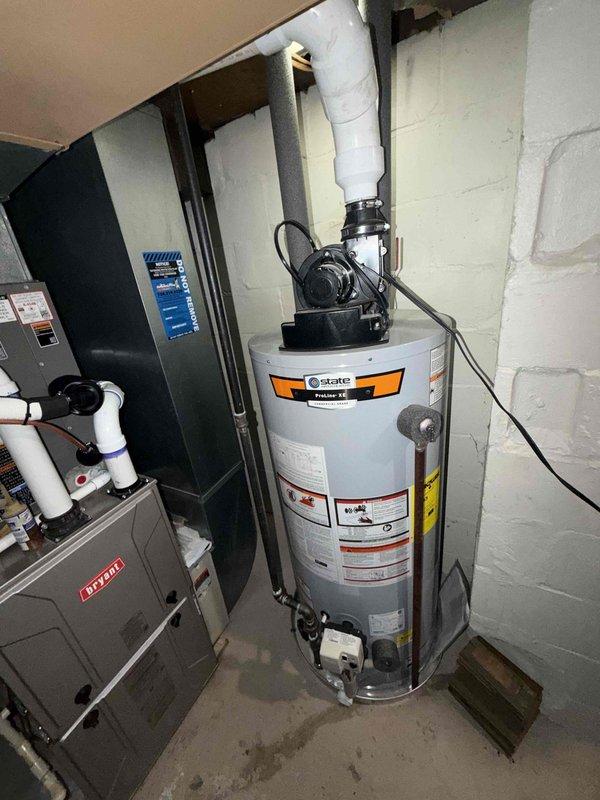 Completed installation of 2-ton Bryant air conditioning system including outdoor condenser unit and indoor evaporator coil. The outdoor condenser was positioned on a concrete pad adjacent to the deck area with proper clearances maintained, while the indoor air handler was installed in the basement utility area with PVC condensate drainage routed to ceiling connection. All mechanical connections, electrical wiring, and refrigerant lines were completed and the system was successfully reconnected and tested for proper operation.