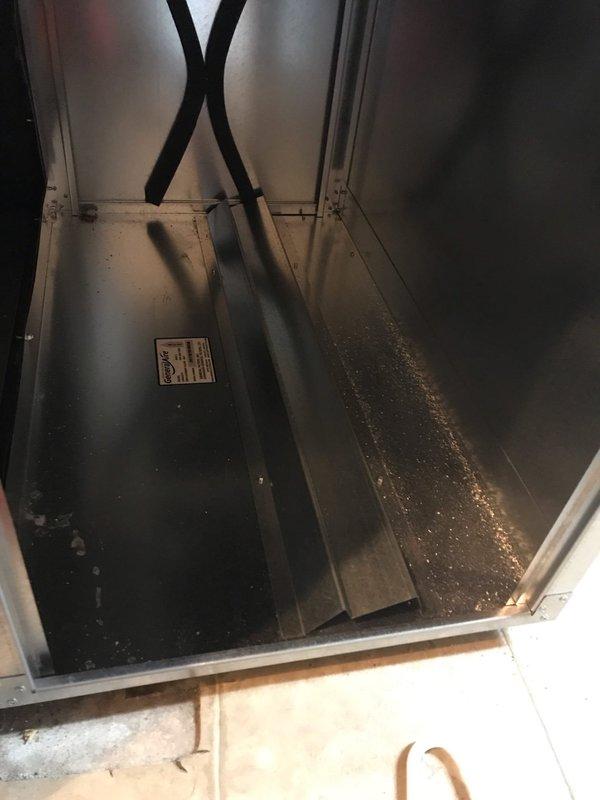 Completed scheduled maintenance visit for air conditioning system under preventative maintenance agreement. Upon inspection, discovered evaporator coil heavily contaminated with dust, dirt, and biological growth accumulation, significantly reducing heat transfer efficiency and airflow. Accessed air handler cabinet and documented interior condition showing moisture staining and general wear consistent with unit age. Performed thorough cleaning of evaporator coil to remove yellowish-green buildup from fins and restore proper airflow. Inspected cabinet interior components, mounting brackets, and support frames for structural integrity. Cleaned condensate drain channels and verified proper drainage to prevent future moisture issues. Unit returned to normal operating condition with improved cooling efficiency.