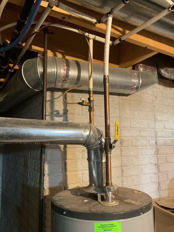 Conducted comprehensive assessment of existing water heater installation in basement mechanical room for replacement estimate. Evaluated current unit configuration, including copper supply piping connections, venting requirements through existing galvanized ductwork, and clearances relative to adjacent furnace system. Documented equipment specifications, existing plumbing connections, and spatial constraints for proper sizing and installation planning of new water heater unit.