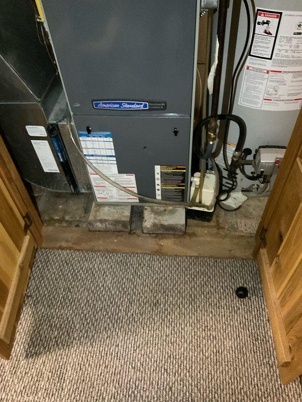 Performed comprehensive evaluation of existing American Standard HVAC system located in basement utility area. Upon inspection, determined that the air conditioning unit has reached end of serviceable life and requires full replacement. Documented current equipment configuration including positioning on concrete blocks, ductwork connections, and spatial constraints within the mechanical room. Provided customer with replacement recommendations and captured photographic documentation of existing installation for estimate preparation purposes.