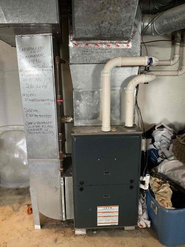 Conducted on-site HVAC system evaluation for equipment replacement estimate in residential basement mechanical room. Assessed existing furnace unit installed December 1996, documented current condition of ductwork, exhaust piping, and associated mechanical components. Photographed equipment specifications, installation details, and surrounding utility infrastructure to provide comprehensive replacement proposal for aging HVAC system.