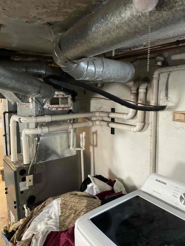 Conducted on-site HVAC system evaluation for equipment replacement estimate in residential basement mechanical room. Assessed existing furnace unit installed December 1996, documented current condition of ductwork, exhaust piping, and associated mechanical components. Photographed equipment specifications, installation details, and surrounding utility infrastructure to provide comprehensive replacement proposal for aging HVAC system.
