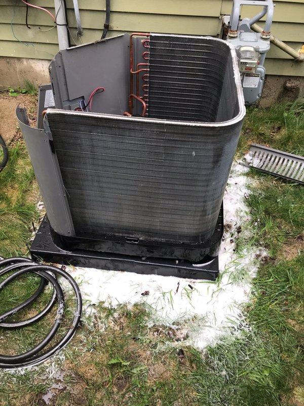 Completed prepaid AC tune-up maintenance visit on residential air conditioning system. Performed comprehensive inspection of outdoor condenser unit, including removal of outer casing to access internal components for thorough cleaning and evaluation. Observed significant dirt and debris accumulation on exterior housing and internal surfaces, with visible weathering and white residue deterioration around top rim edges. Inspected electrical control boxes, wiring connections, and refrigerant line routing to ensure proper operation. Examined condenser coils with aluminum fins on multiple sides for airflow efficiency. Verified unit mounting on platform pad and assessed overall system condition. Documented equipment condition through photographs showing internal components, copper refrigerant lines, and external housing. System operational upon completion of maintenance procedures.