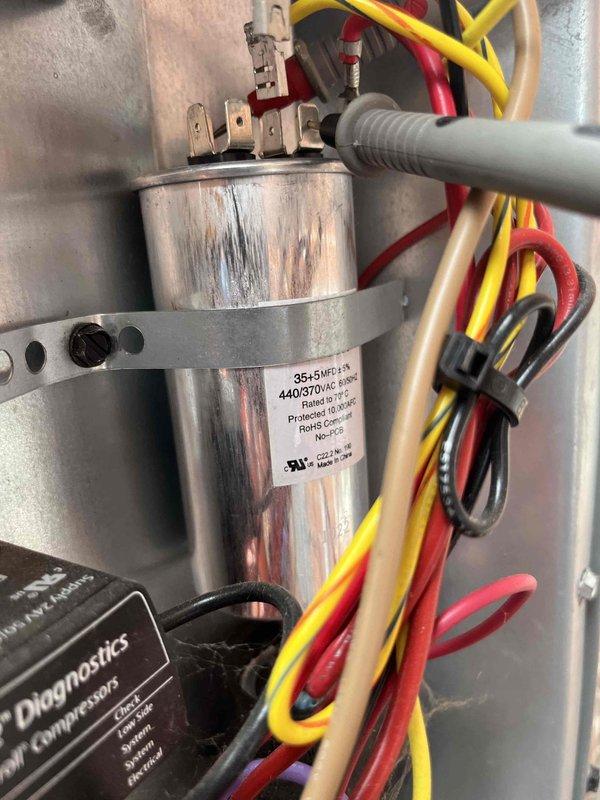 Completed annual air conditioner tune-up on residential AC system. Performed comprehensive electrical diagnostics using clamp meter to verify proper amperage draw and voltage readings on compressor circuit. Inspected dual-run capacitor (35+5 MFD, 440/370VAC rated) for proper operation and terminal connections, verified all wire connections secure at capacitor terminals including compressor and fan motor circuits. System operating within manufacturer specifications, all electrical components functioning properly.