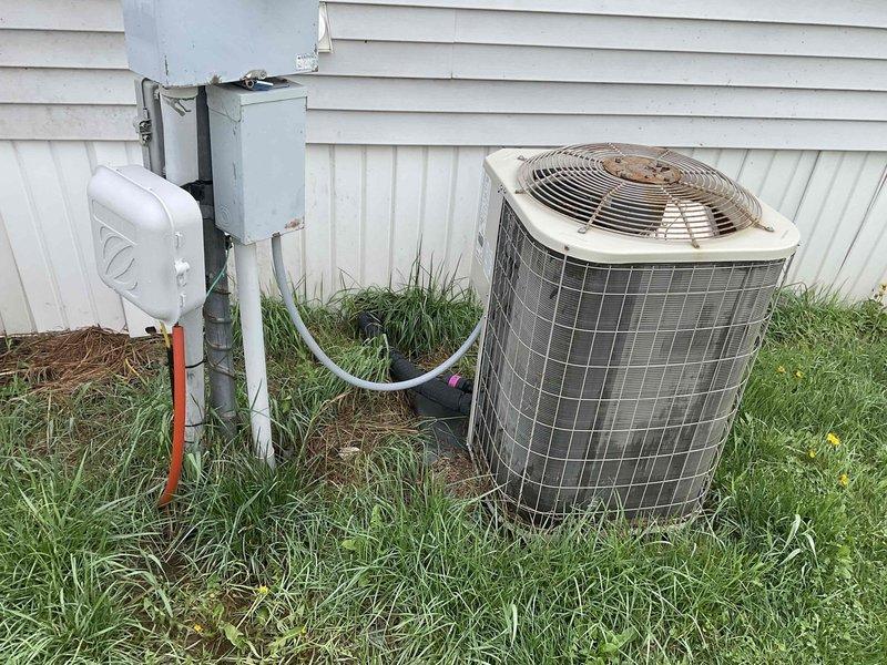 Conducted on-site evaluation of existing HVAC system at mobile home for complete furnace and air conditioning replacement estimate. Assessed aging outdoor condensing unit showing significant weathering and deterioration, documented electrical disconnect box and associated conduit routing. Inspected interior electrical panel to verify circuit capacity and breaker configuration for new equipment installation requirements. Photographed existing equipment placement, clearances, and electrical infrastructure to develop accurate replacement proposal for complete heating and cooling system upgrade.
