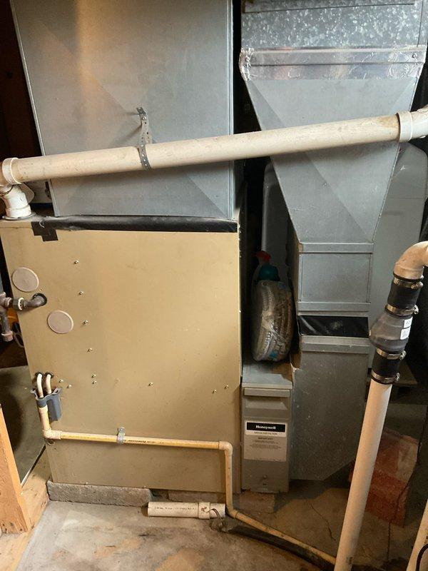 Conducted on-site evaluation of existing 80% efficiency furnace installation in basement of small two-story residence with no current central air conditioning system. Assessed existing ductwork, electrical service, gas line configuration, and available space for potential air conditioning component integration. Documented current HVAC system configuration including furnace cabinet, supply and return ductwork, PVC condensate drain lines, and gas piping to provide comprehensive replacement options for both 80% and 90% efficiency furnace units with complete central air conditioning systems.