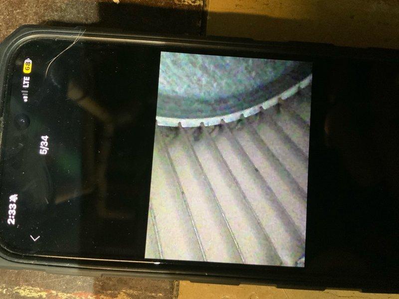 Responded to no-cool complaint on 9-year-old central air conditioning system. Customer reported inadequate cooling performance with temperature dropping only 4 degrees over 5 hours and outdoor unit discharging cool air instead of normal hot air, indicating refrigerant circuit issue. Upon inspection, identified significant rust staining and corrosion inside evaporator coil assembly, confirmed through borescope camera inspection of ductwork and coil housing. Rust bleeding pattern suggests advanced deterioration of evaporator coil with likely refrigerant leak. Documented internal coil damage with inspection camera showing extent of corrosion on coil surfaces. Outdoor unit discharging cool air confirms loss of refrigerant charge and system operating in failed state with compressor running but no heat transfer occurring. Recommended evaporator coil replacement due to corrosion damage and system recharge with proper refrigerant after leak repair. Customer provided photographic evidence of in