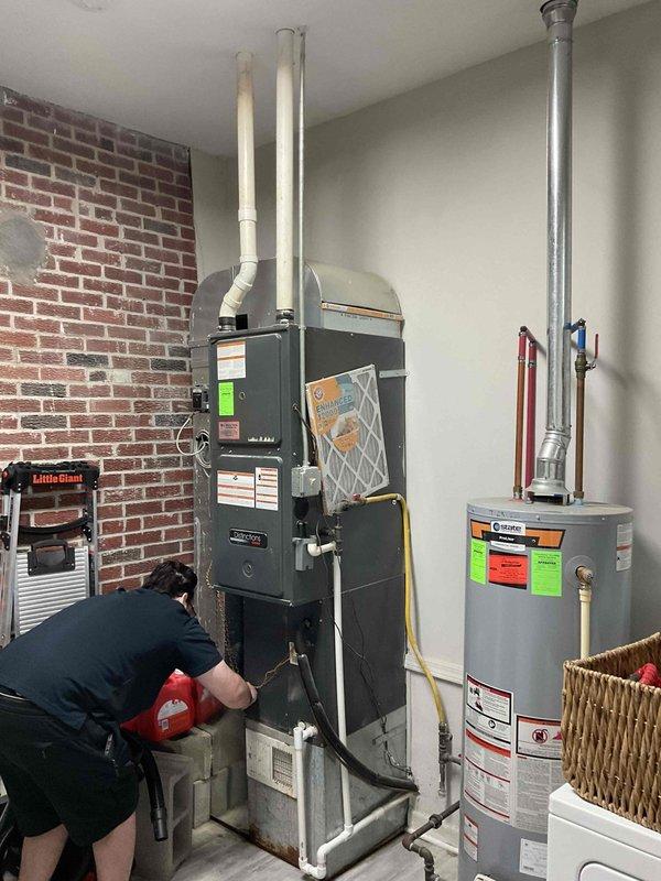 Conducted on-site assessment for mini split system installation to replace failed air conditioning compressor unit. Evaluated existing HVAC infrastructure including furnace, water heater, and outdoor condenser unit located on concrete pad adjacent to building foundation. Documented current equipment conditions, utility connections, electrical disconnect box, and PVC piping configuration to determine optimal placement and specifications for new mini split system installation.