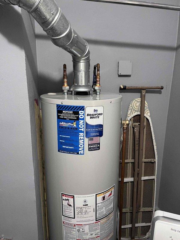 Installed a new 40-gallon Bradford White tank-style water heater in utility room, connecting water supply lines with brass shut-off valves and copper piping, and securing the exhaust vent system with proper galvanized venting and metal clamps. Completed all reconnections to ensure proper hot water delivery and verified unit operation upon installation completion.