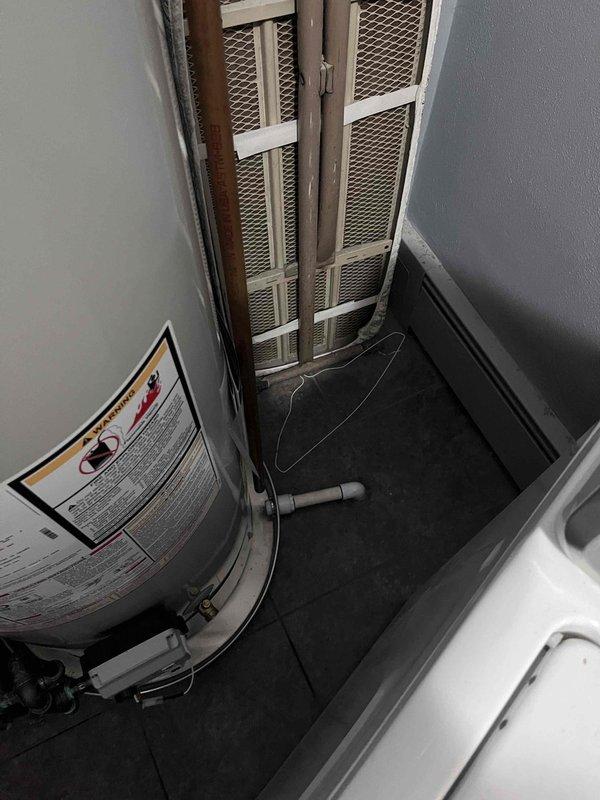 Installed a new 40-gallon Bradford White tank-style water heater in utility room, connecting water supply lines with brass shut-off valves and copper piping, and securing the exhaust vent system with proper galvanized venting and metal clamps. Completed all reconnections to ensure proper hot water delivery and verified unit operation upon installation completion.