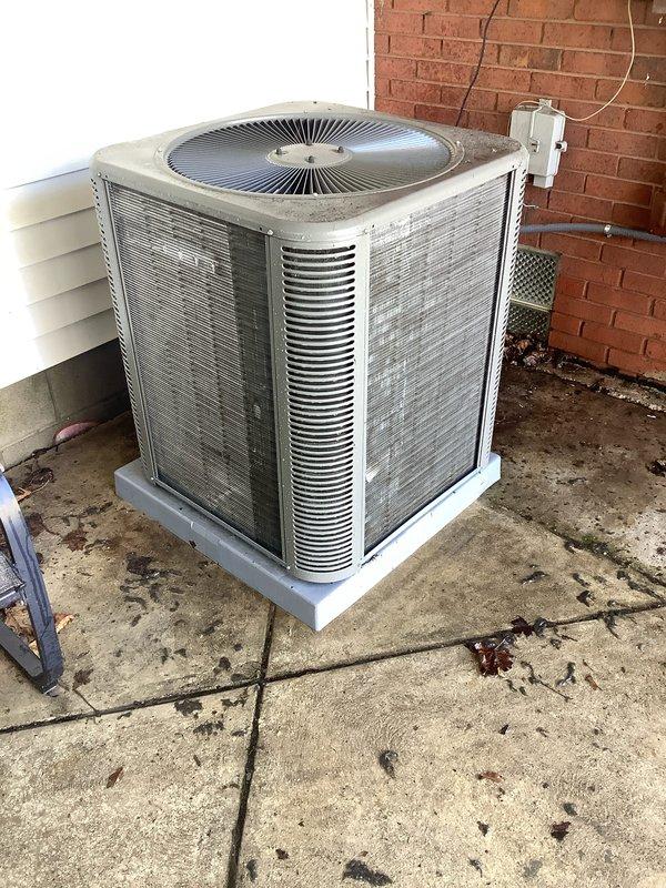 Completed pre-season air conditioning tune-up on a two-year-old residential AC system. Performed comprehensive inspection of outdoor condenser unit, which showed normal weathering and surface accumulation consistent with age. Cleaned condenser coils and exterior panels to remove dirt, debris, and organic growth from louvered grilles. Verified proper operation of condenser fan and checked electrical connections at disconnect box. Inspected condensing pad for stability and drainage. Measured refrigerant pressures and confirmed system is operating within manufacturer specifications. All components functioning properly with no immediate repairs required. System is ready for cooling season operation.