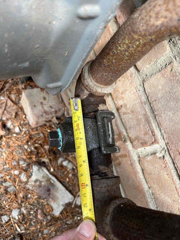 Completed city boiler inspection #10-2289 with photographic documentation of system components. Measured and assessed outdoor piping infrastructure, noting significant corrosion on existing brown metal pipe connections requiring future monitoring. Inspected indoor HVAC filtration system, documenting accumulated dust and debris on mesh filter pad with diamond-pattern lattice structure, indicating normal operational wear since last service interval.