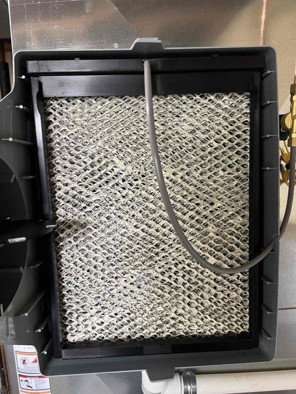 Completed city boiler inspection #10-2289 with photographic documentation of system components. Measured and assessed outdoor piping infrastructure, noting significant corrosion on existing brown metal pipe connections requiring future monitoring. Inspected indoor HVAC filtration system, documenting accumulated dust and debris on mesh filter pad with diamond-pattern lattice structure, indicating normal operational wear since last service interval.