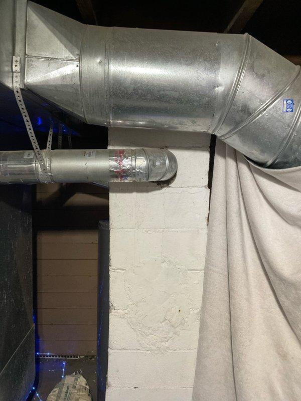 Completed comprehensive HVAC system replacement estimate for 10-12 ton capacity installation. Evaluated existing ductwork infrastructure in basement utility area, including galvanized sheet metal trunk lines and branch ducts, and assessed exterior equipment placement area with two existing condenser units positioned against foundation. Documented current system configuration and site conditions to prepare detailed replacement proposal for veteran homeowner requiring financing options.