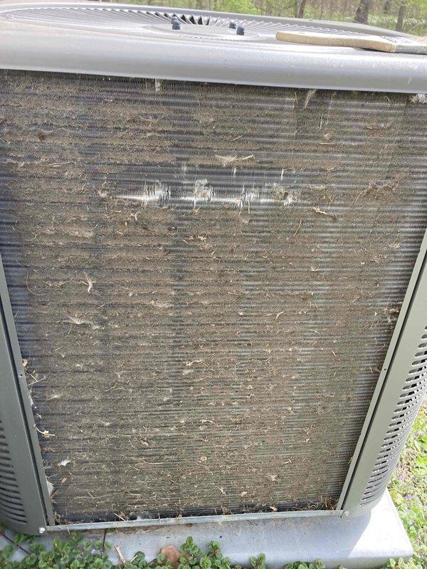Completed annual cooling maintenance tune-up on residential HVAC system. Performed electrical diagnostics using multimeter, recording voltage readings at outdoor condenser unit. Identified heavily clogged condenser coil fins with significant dirt and debris accumulation restricting airflow; cleaned coils to restore proper system operation and efficiency. System confirmed operational upon completion.
