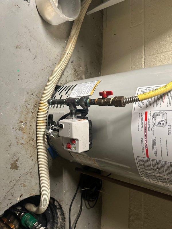 Completed installation of residential tanked water heater in basement utility room. Connected hot and cold water supply lines using copper piping and flexible braided hoses with appropriate shut-off valves. Installed yellow flexible gas line connection to unit and verified proper gas flow. Routed corrugated metal exhaust vent duct for proper ventilation. Connected electrical power supply and verified operational functionality. Installed temperature and pressure relief valve with discharge piping per code requirements. Tested all plumbing connections for leaks and confirmed water heater is heating properly and operating safely.
