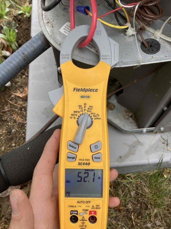 Performed AC club maintenance visit for system experiencing furnace operational issues. Conducted electrical diagnostics on outdoor condensing unit using clamp meter, recording inrush current reading of 52.1 amps at compressor circuit. Inspected evaporator coil assembly and verified refrigerant line connections at brass service valves. All electrical connections at outdoor unit terminal block examined and found secure with proper wire routing through conduit. System components showed normal operational wear with some dust accumulation on condenser housing and minor residue buildup on evaporator coil surfaces.