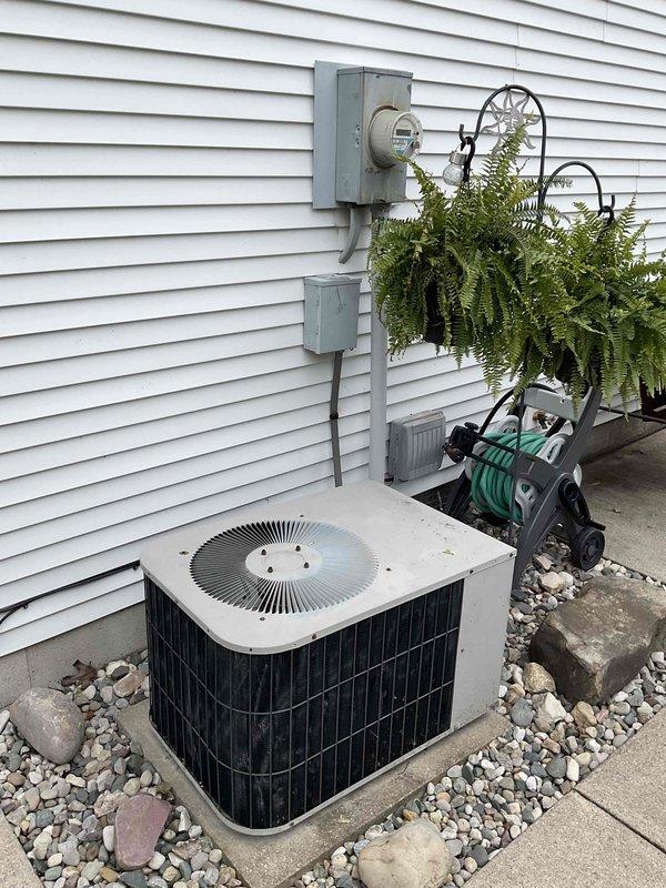 Performed complimentary estimate for complete HVAC system replacement including 20-year-old furnace and air conditioning condenser unit. Inspected existing outdoor AC unit on concrete pad with electrical disconnect, evaluated electrical panel and circuit breaker configuration, and documented current system conditions. Provided replacement options and recommendations for new heating and cooling equipment installation.