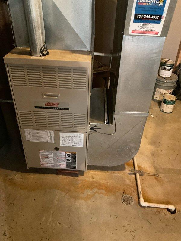 # HVAC System Estimate - Replacement Assessment

Conducted comprehensive assessment of existing Lennox furnace system located in basement utility area for replacement estimate. Evaluated current equipment configuration including furnace unit, metal ductwork system, and air handler components. Documented existing installation showing furnace with ventilation louvers, manufacturer specification labels, and connected galvanized steel ductwork extending vertically with horizontal connections. Noted flexible black ductwork at ceiling level and metallic elbow duct connections. Photographed complete system layout including equipment positioning against wall framing, PVC drainage piping, and floor drain location for replacement planning purposes. Provided detailed system estimate for 8-10 SEER replacement equipment options.