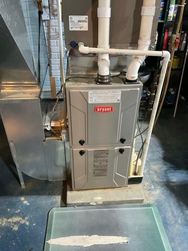 Completed comprehensive HVAC system assessment and provided replacement estimate for existing Bryant furnace and air conditioning system. Documented current equipment configuration including vertically stacked components, PVC venting system with pressure monitoring, and associated ductwork in basement utility area. Evaluated installation for replacement specifications covering heating and cooling equipment upgrade requirements.