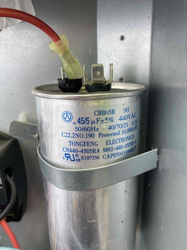 Completed preventive maintenance inspection on air conditioning system under Club AC8-12 agreement. Inspected dual-run capacitor rated at 45/5 μF, 440VAC, confirmed proper electrical connections and secure mounting. Observed evaporator coil with moderate to heavy dust and debris accumulation on fins, particularly concentrated in upper sections. Noted visible mold and mildew growth on interior surfaces and drain pan area, with moisture staining present on adjacent housing panels. System operational at time of inspection. Documented conditions with photographs for maintenance records.