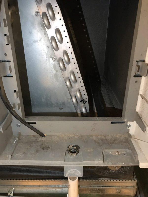 Completed preventive maintenance inspection on air handler unit as part of Club AC10-2 agreement. Performed visual inspection of internal components including evaporator coil housing, drain pan, and condensate drainage system. Documented existing conditions showing moderate dirt and debris accumulation in drain pan and significant corrosion on metal support frame at base of unit. Condensate drain line confirmed in place and operational. All interior components accessible and photographed for service records.