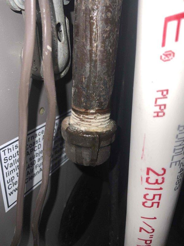Responded to no heat call with reported odor from furnace. Upon inspection, discovered severely corroded and rusted metal piping connections in the condensate drainage system. The deteriorated pipe fittings were releasing metallic odor when furnace operated and posed risk of condensate leakage. Documented existing condensate pump installation on drain pan and condition of associated PVC drainage lines. Identified the corroded metal pipe section requiring replacement to eliminate odor and prevent future drainage issues. Advised replacement of affected piping components to restore proper condensate management and eliminate smell.