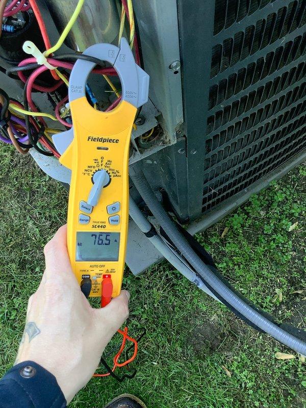 Completed preventative maintenance agreement visit for Club AC8-12 service on residential air conditioning system. Performed comprehensive electrical diagnostics using clamp meter, recording amperage reading of 76.5 amps at outdoor condensing unit. Inspected all electrical connections at terminal block, verified proper wire routing and connections including line voltage wiring and low voltage control circuits. Examined capacitor condition and mounting hardware, noting normal operational wear. All electrical components functioning within manufacturer specifications. System operational upon completion of maintenance visit.