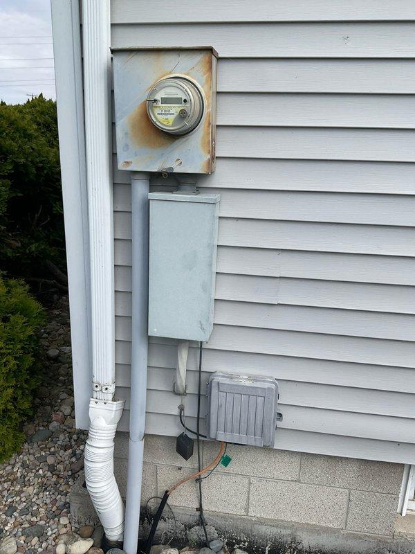 Completed comprehensive electrical estimate for whole home generator installation. Assessed existing electrical infrastructure including main service panel, meter base showing weather deterioration and rust staining, and current electrical distribution system. Evaluated optimal generator placement considering proximity to existing HVAC unit on concrete pad, available space in landscaped area with river rock ground cover, and accessibility for fuel line connections. Documented existing electrical components including gray junction boxes, conduit routing, and disconnect switch locations to determine transfer switch installation requirements and necessary electrical upgrades for generator integration with home's electrical system.