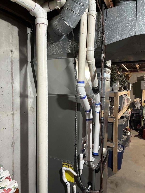 Completed full HVAC system installation including a 90,000 BTU furnace, 3-ton air conditioning unit positioned on the right side, and humidifier integration. Performed all mechanical and electrical connections, installed proper venting with white PVC piping, and configured ductwork with galvanized sheet metal components. System was reconnected, tested for proper operation, and left in full working order.