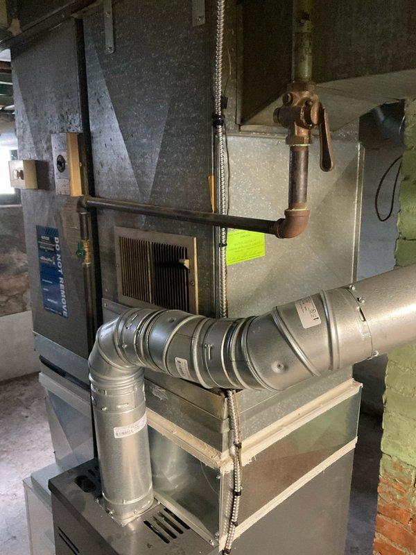 Completed HVAC system replacement estimate for residential property. Installation includes vertically-stacked furnace and air handler configuration with proper refrigerant line connections, metallic flexible ductwork, and all necessary mounting hardware in basement mechanical room.