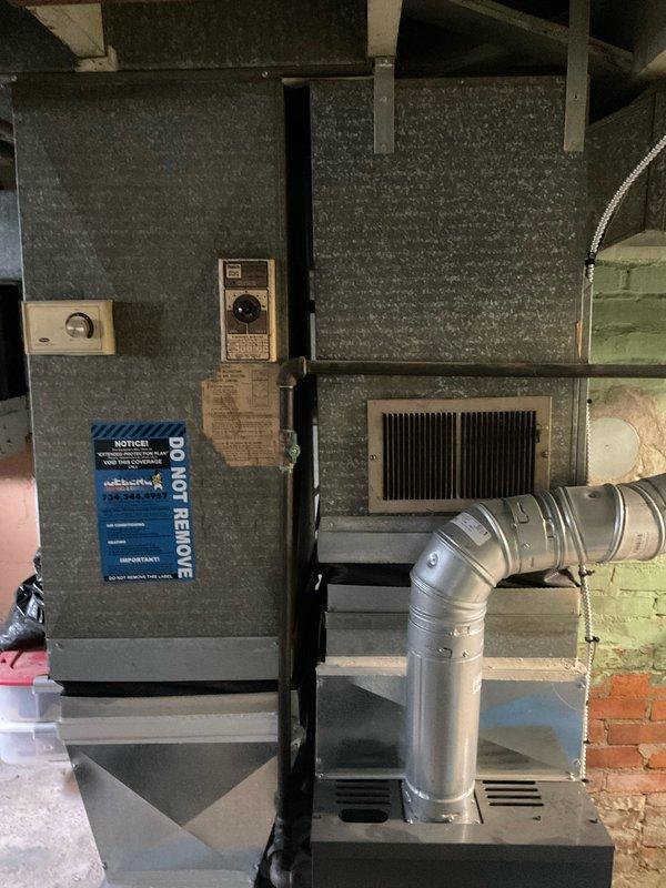 Completed HVAC system replacement estimate for residential property. Installation includes vertically-stacked furnace and air handler configuration with proper refrigerant line connections, metallic flexible ductwork, and all necessary mounting hardware in basement mechanical room.