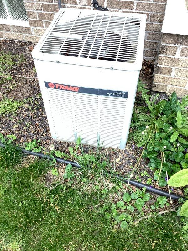 Completed preventive maintenance agreement visit on Trane high-efficiency outdoor condensing unit. Performed comprehensive AC&SI inspection including cleaning condenser coils, checking refrigerant levels, testing electrical connections, verifying proper airflow through louvers, and inspecting disconnect box functionality. Noted vegetation growth around unit base requiring customer attention to maintain proper clearance for optimal system performance and airflow.