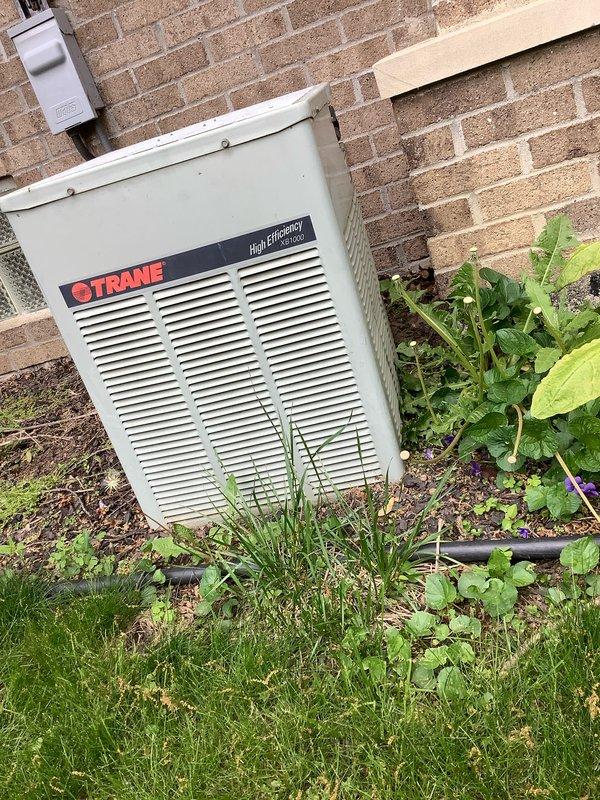 Completed preventive maintenance agreement visit on Trane high-efficiency outdoor condensing unit. Performed comprehensive AC&SI inspection including cleaning condenser coils, checking refrigerant levels, testing electrical connections, verifying proper airflow through louvers, and inspecting disconnect box functionality. Noted vegetation growth around unit base requiring customer attention to maintain proper clearance for optimal system performance and airflow.