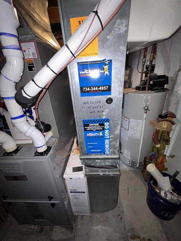 Completed full installation of new air conditioning system including outdoor condensing unit and indoor evaporator coil. Outdoor unit was positioned on concrete pad against house exterior with proper clearance, electrical disconnect mounted on exterior wall, and refrigerant lines run through wall penetration. Indoor evaporator coil was installed above existing furnace in basement mechanical room with new condensate drain line connected to existing drainage system. System was charged with refrigerant, leak tested, and verified for proper operation with all electrical connections completed to code.