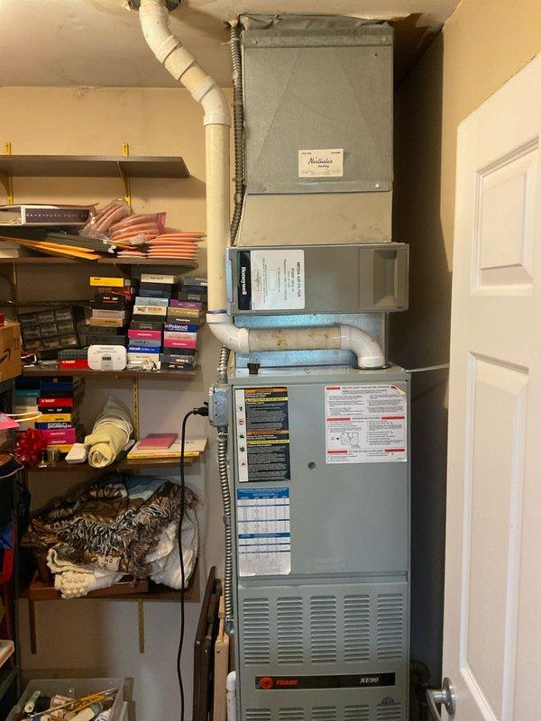 Conducted comprehensive evaluation of dual HVAC systems, both approximately 25 years old. Assessed two Trane furnaces with failed heat exchangers and two R-22 air conditioning systems. Documented existing equipment configurations including vertically stacked utility closet installation with condensate drainage and electrical components. Prepared detailed replacement estimates for complete system upgrades on both units due to age of equipment and critical heat exchanger failures that render current furnaces unsafe for operation.