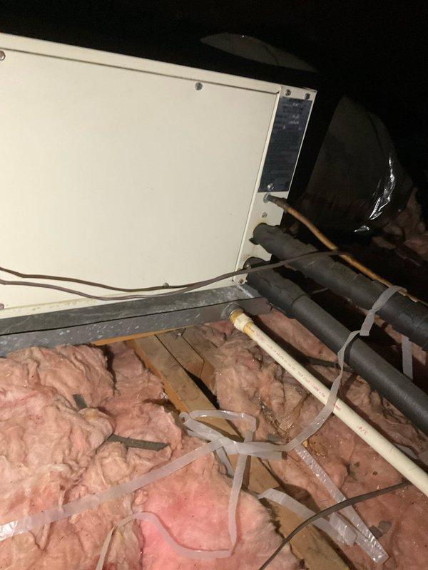 Conducted attic inspection and assessment of existing HVAC air handler system to provide replacement estimate for air conditioning equipment. Documented current installation including white air handler unit, refrigerant line sets with black insulation, electrical connections, and flexible ductwork. Photographed equipment specifications, warning labels, and existing mechanical components to develop accurate quote for AC system replacement. Discussed financing options with customer for proposed equipment upgrade.