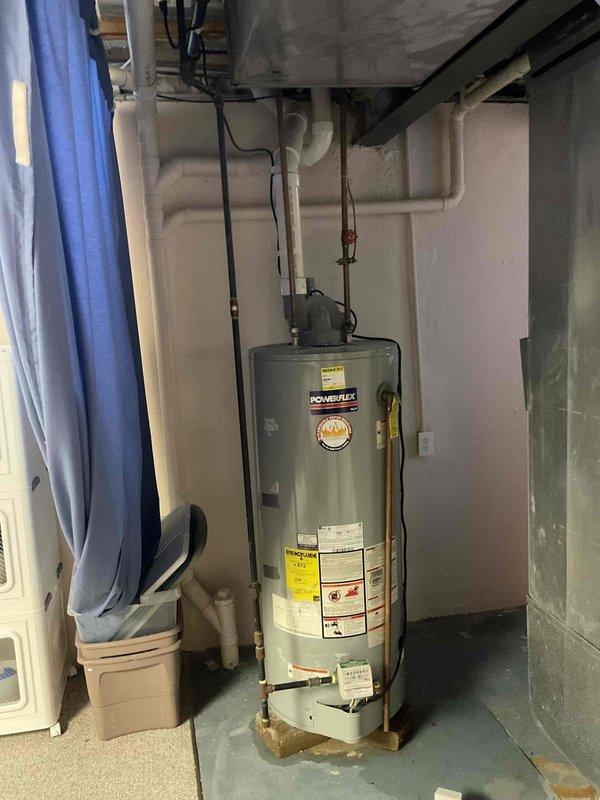 Conducted comprehensive assessment of existing Powerflex water heater installation in basement utility area for replacement estimate. Documented current unit specifications, connections including copper supply lines with shutoff valve, electrical service, and PVC venting system configuration. Evaluated surrounding infrastructure including spray foam insulation coverage, available clearances, and access for equipment removal and installation.