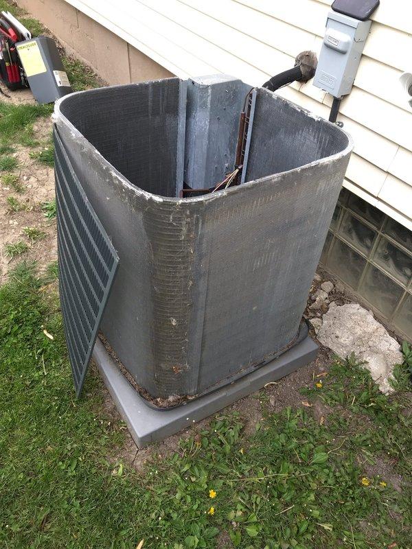 Completed preventive maintenance agreement visit on outdoor AC condensing unit. Upon arrival, found unit with outer casing completely removed, exposing condenser coil to elements with significant weathering, rust, discoloration, and debris accumulation throughout. Condenser coil showed heavy soiling with dirt and dust buildup on finned surfaces, compromising heat transfer efficiency. Inspected refrigerant lines and electrical connections, noting copper lines and insulation present but unit operating in severely compromised condition due to missing protective housing and environmental exposure. Documented extensive deterioration along coil edges and seams, with debris accumulation in surrounding area requiring attention for proper airflow and system protection.