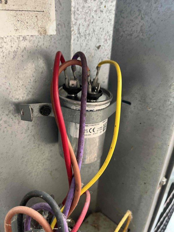 Responded to emergency no-cooling call on thirteen-year-old air conditioning system. Upon inspection, found severely corroded contactor with deteriorated terminals and significant environmental damage affecting electrical connections. Documented existing capacitor and wiring configuration showing multiple compromised connection points due to age and exposure. System components displayed extensive oxidation, grime accumulation, and general wear consistent with unit age, requiring immediate attention to restore cooling operation.