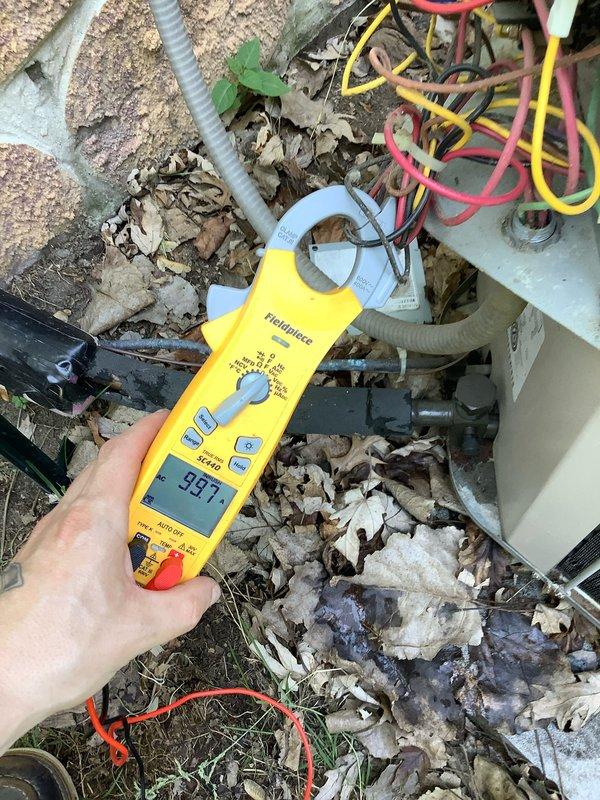 Responded to no cooling call on 10+ year old Carrier outdoor unit model CCU10A36A-1. Upon arrival, found unit not communicating with thermostat despite customer replacing batteries. Performed diagnostic testing using clamp meter, which revealed electrical readings of 99.7 amps indicating compressor attempting to operate outside normal parameters. Inspected outdoor unit and found substantial debris accumulation including leaves, dirt, and organic material surrounding equipment and wiring connections. Noted unit contains R-22 refrigerant and is rated for 208-230V operation with 18.0 RLA compressor specifications. Identified communication failure between thermostat and outdoor unit as primary issue preventing proper cooling operation. Customer declined equipment replacement at this time.