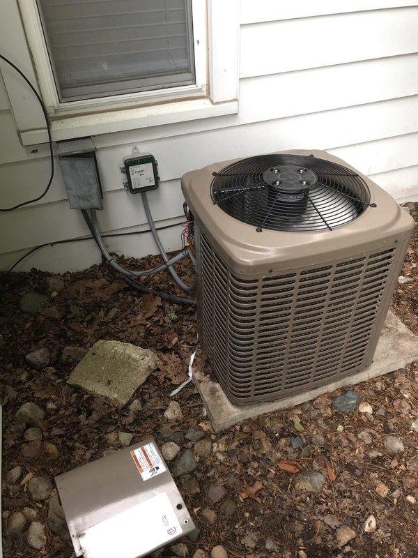 Responded to callback for non-operational air conditioning unit. Upon arrival, performed visual inspection of outdoor condenser unit and associated electrical components. Inspected disconnect box mounted on exterior wall, noting visible rust and corrosion within enclosure that could affect electrical connections and system performance. Evaluated condenser unit positioning, electrical supply routing, and overall installation condition. Documented equipment condition through photographs showing disconnect box interior with corroded components and condenser unit placement on concrete pad. Assessed potential electrical connection issues related to weathered disconnect box that may have contributed to system failure reported by customer.