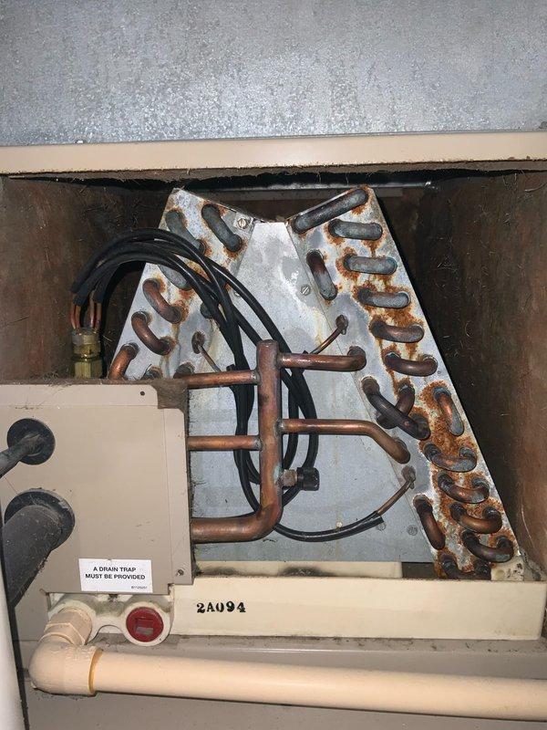 # AC No Cool - Fan Motor Failure

## Summary
Responded to no cooling call on 10+ year old system with non-operational blower fan. Diagnosed failed blower motor and capacitor. Evaporator coil showed extensive corrosion indicating advanced age and moisture exposure throughout unit.

## Work Performed

Upon arrival, confirmed air handler blower motor not operating. Performed diagnostic inspection of indoor unit components. Accessed blower compartment and tested motor capacitor - found failed with no charge. Inspected motor windings and bearings - motor seized and required replacement.

Examined electrical control board mounted to blower assembly. Verified board connections and tested for proper voltage supply. All indicator lights and fuses showed normal operation. Control board functionality confirmed adequate.

Inspected evaporator coil assembly during diagnostic process. Noted heavy rust and corrosion on copper tubing throughout coil serpentine pattern. Corrosion consistent with age-re