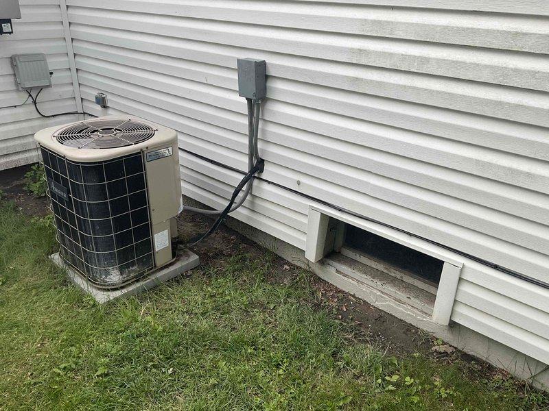 Conducted on-site evaluation for air conditioning replacement estimate at residential property. Assessed existing outdoor condenser unit positioned on concrete pad with standard electrical connections and indoor furnace system located in utility/laundry room. Documented current equipment configuration including ductwork, drainage systems, and electrical service to provide accurate replacement specifications for new AC system.
