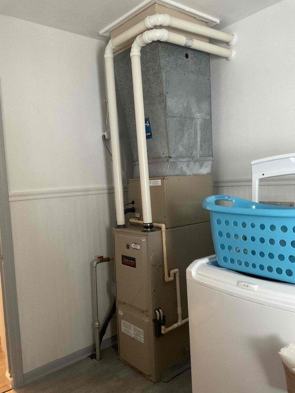 Conducted on-site evaluation for air conditioning replacement estimate at residential property. Assessed existing outdoor condenser unit positioned on concrete pad with standard electrical connections and indoor furnace system located in utility/laundry room. Documented current equipment configuration including ductwork, drainage systems, and electrical service to provide accurate replacement specifications for new AC system.