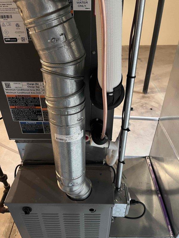 Completed installation of 2.5 ton air conditioning system with evaporator coil, including mechanical and electrical connections for rear-discharge unit. Installed new Honeywell ProSeries digital thermostat for heating and cooling control, connected ductwork to air handler, and performed final system reconnection and startup to ensure proper operation.