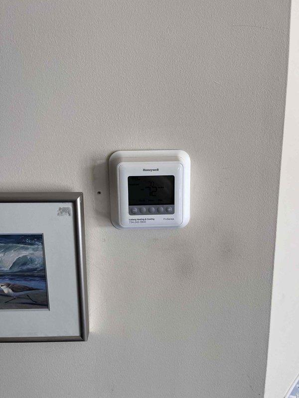 Completed installation of 2.5 ton air conditioning system with evaporator coil, including mechanical and electrical connections for rear-discharge unit. Installed new Honeywell ProSeries digital thermostat for heating and cooling control, connected ductwork to air handler, and performed final system reconnection and startup to ensure proper operation.