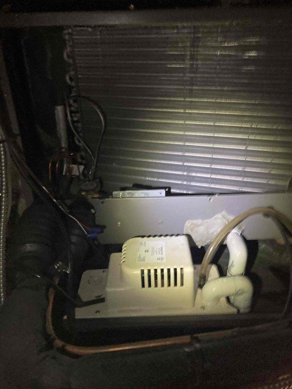 Responded to call back for air conditioning unit not turning on. Upon inspection, found condensate pump and associated drainage components within the air handler. Examined evaporator coil showing signs of dust accumulation and age-related buildup. Inspected copper refrigerant lines, electrical connections, and pump wiring for proper operation. Verified all mechanical components were properly seated and drainage system was functioning correctly to restore unit operation.