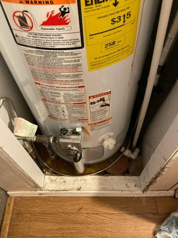 Completed on-site assessment and documentation for water heater replacement estimate. Inspected existing gas-fired water heater installation in residential utility closet, noting current unit configuration, connection points, and surrounding infrastructure. Photographed water heater with visible safety labels, energy guide information, and gas control valve assembly at base. Documented existing piping connections including gas line with copper tubing and water supply lines. Observed platform mounting with minor water staining on wooden base, indicating potential previous minor leakage or condensation. Evaluated venting system penetration through wall with metal escutcheon plate and spray foam insulation sealing. Assessment included review of clearances, access requirements, and existing utility connections to provide accurate replacement estimate.