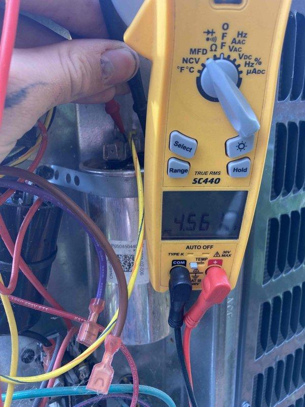 Completed AC Club 12-4 preventive maintenance agreement visit on residential air conditioning system. Performed comprehensive electrical diagnostics using digital multimeter, measuring voltage readings on capacitor terminals which displayed 456V and 446.7V respectively, confirming proper electrical operation within manufacturer specifications. Inspected all electrical connections, wiring harness, and capacitor condition as part of seasonal inspection protocol.